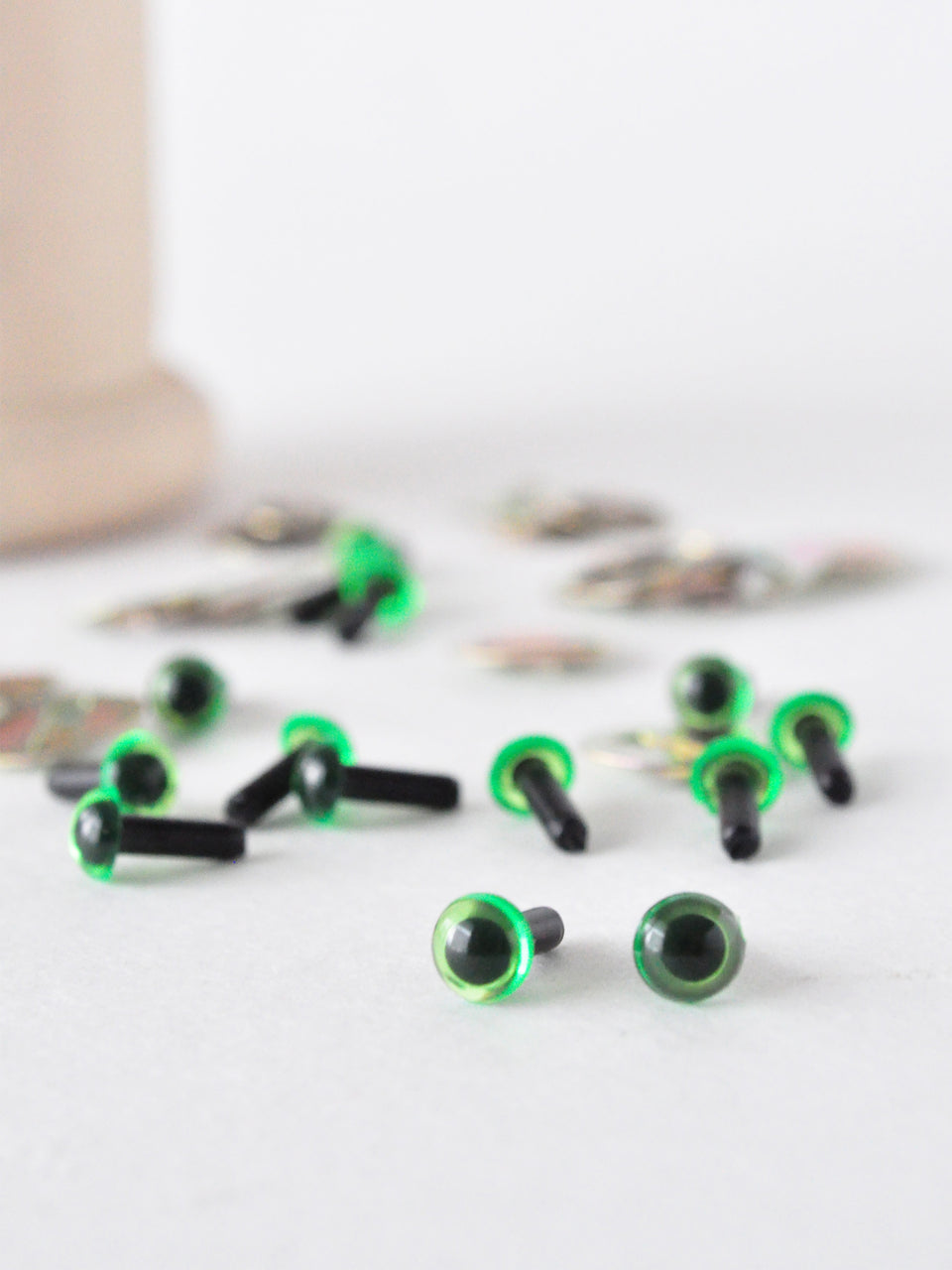 4.5mm translucent green safety eyes for crafting on a white surface.