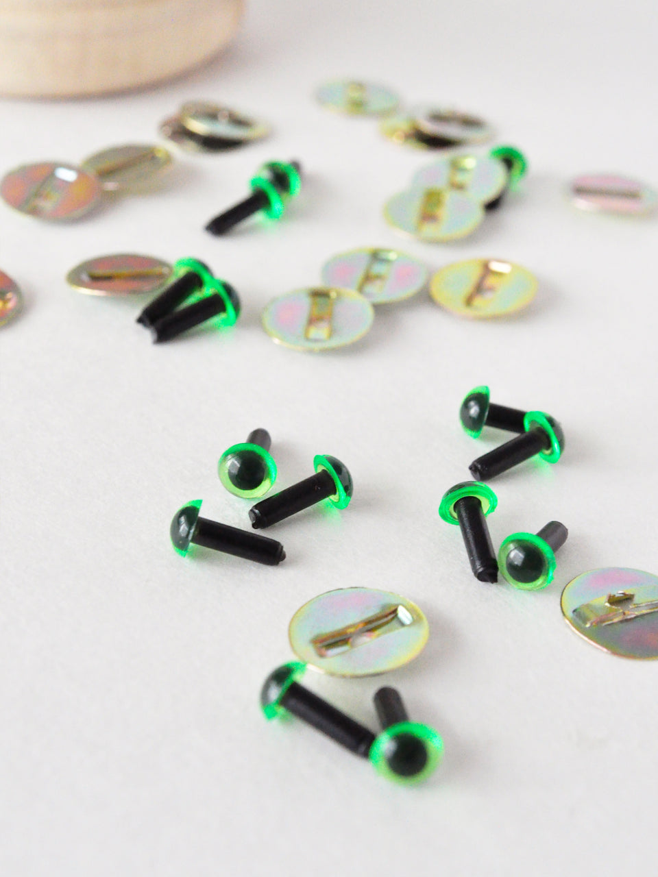 4.5mm translucent green safety eyes with metal washers spread across a white surface