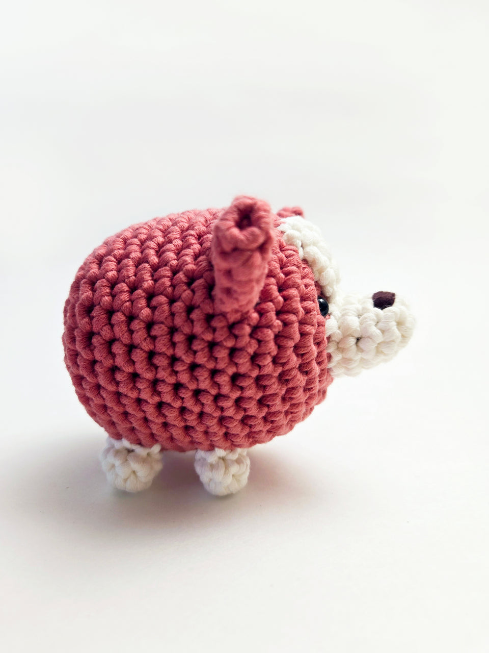 Side view of a chubby red and white crochet corgi.