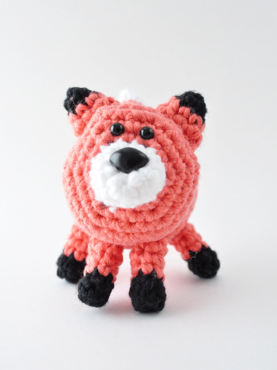 Crocheted fox on a white background, crochet pattern by The Pudgy Rabbit.