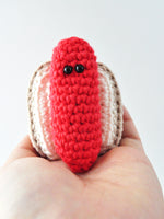 crocheted hot dog being held in the palm of a hand
