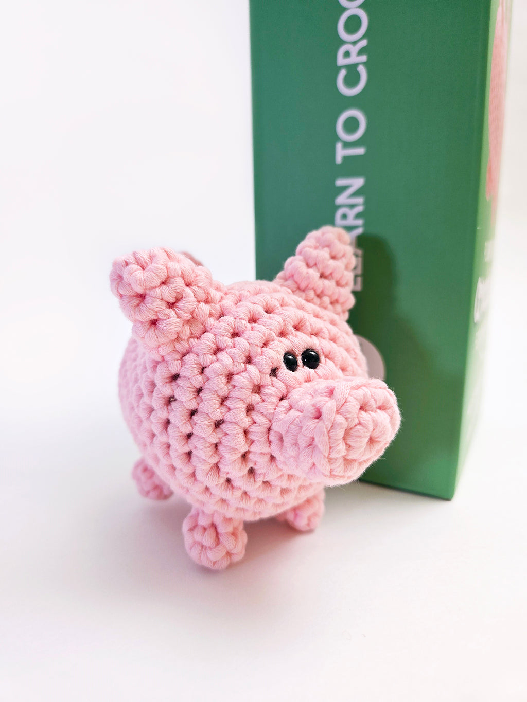 Three quarter view of pink pig amigurumi.