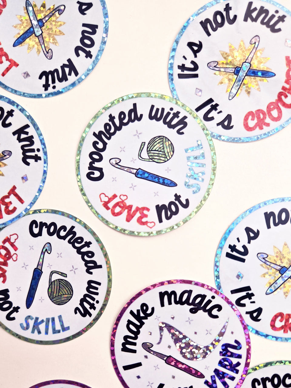 Glittery crochet stickers spread over a white background.