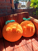 crochet orange pillow pattern on striped couch